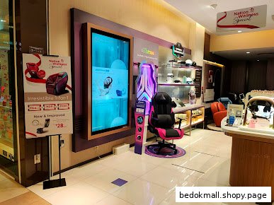 Interior view of an OSIM shop displaying wellness products, a gaming chair, and digital screen.
