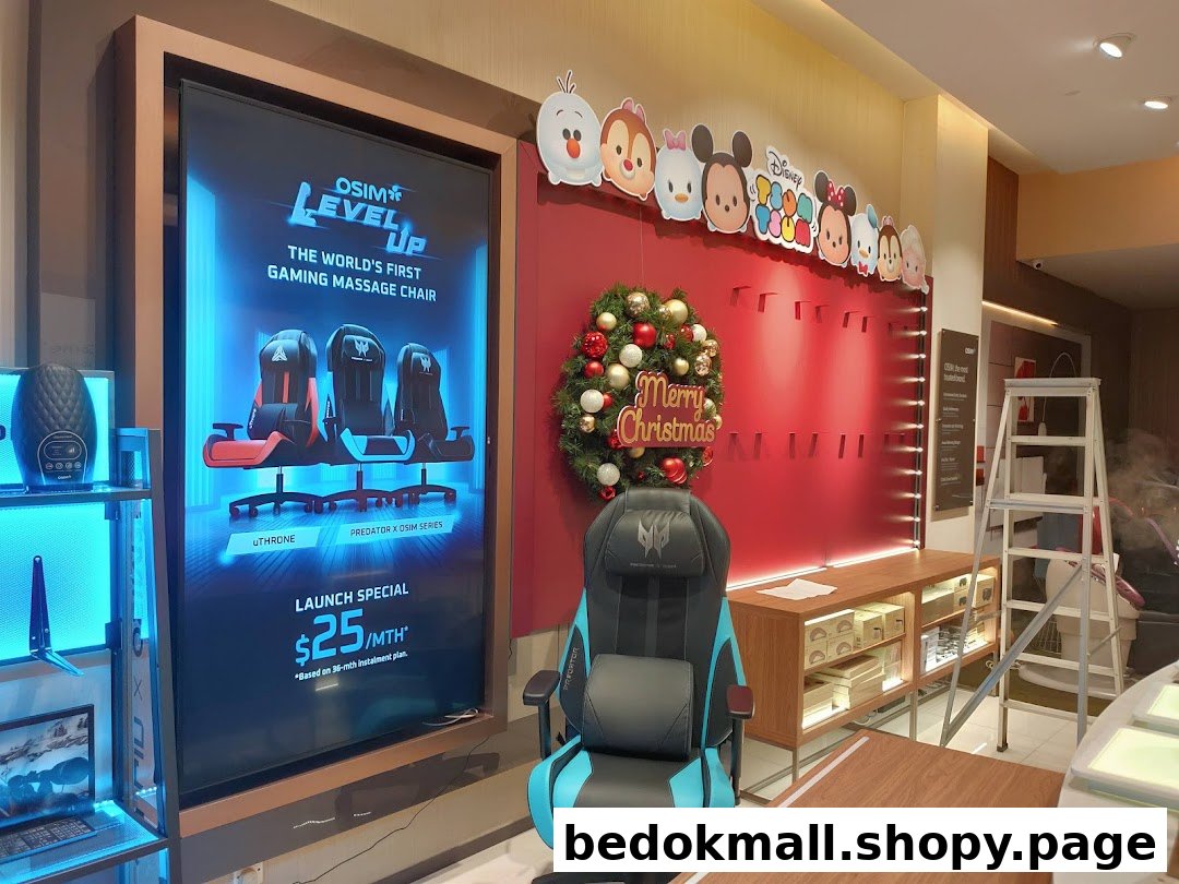 Shop interior with a gaming massage chair display, digital ad, and Christmas decor.