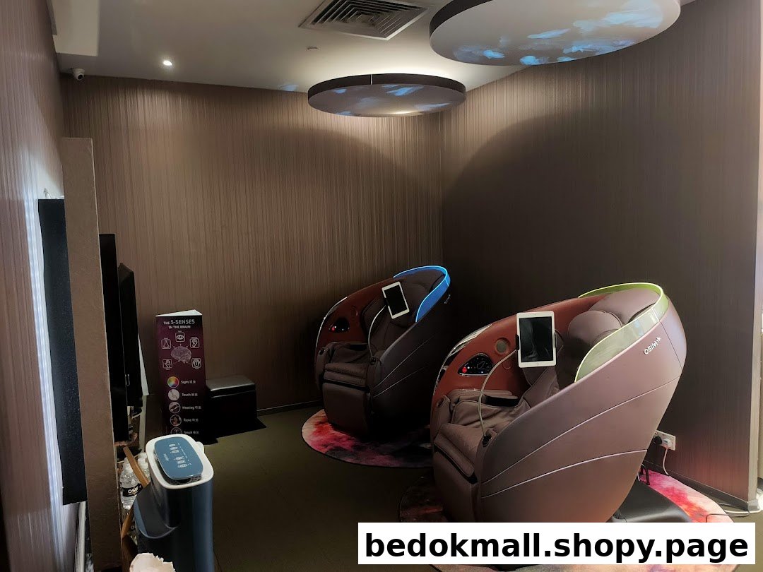 Two massage chairs are displayed in a shop interior with promotional materials.