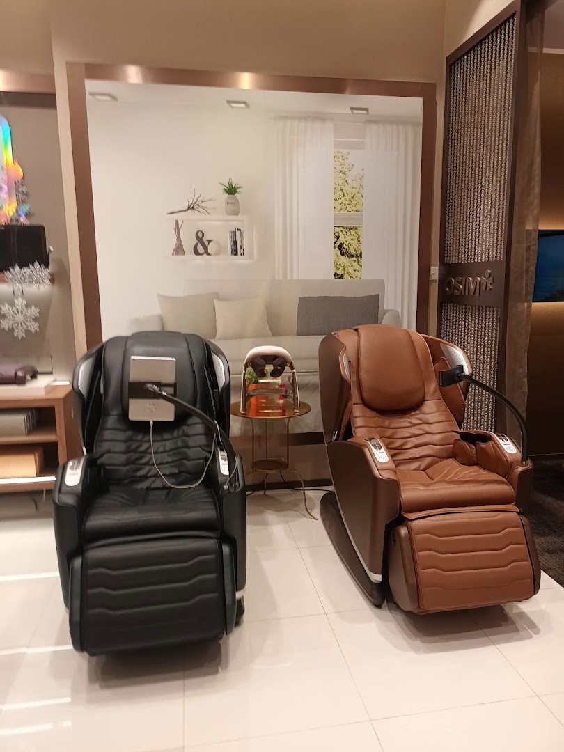 Two massage chairs displayed in a retail showroom with a living room backdrop.