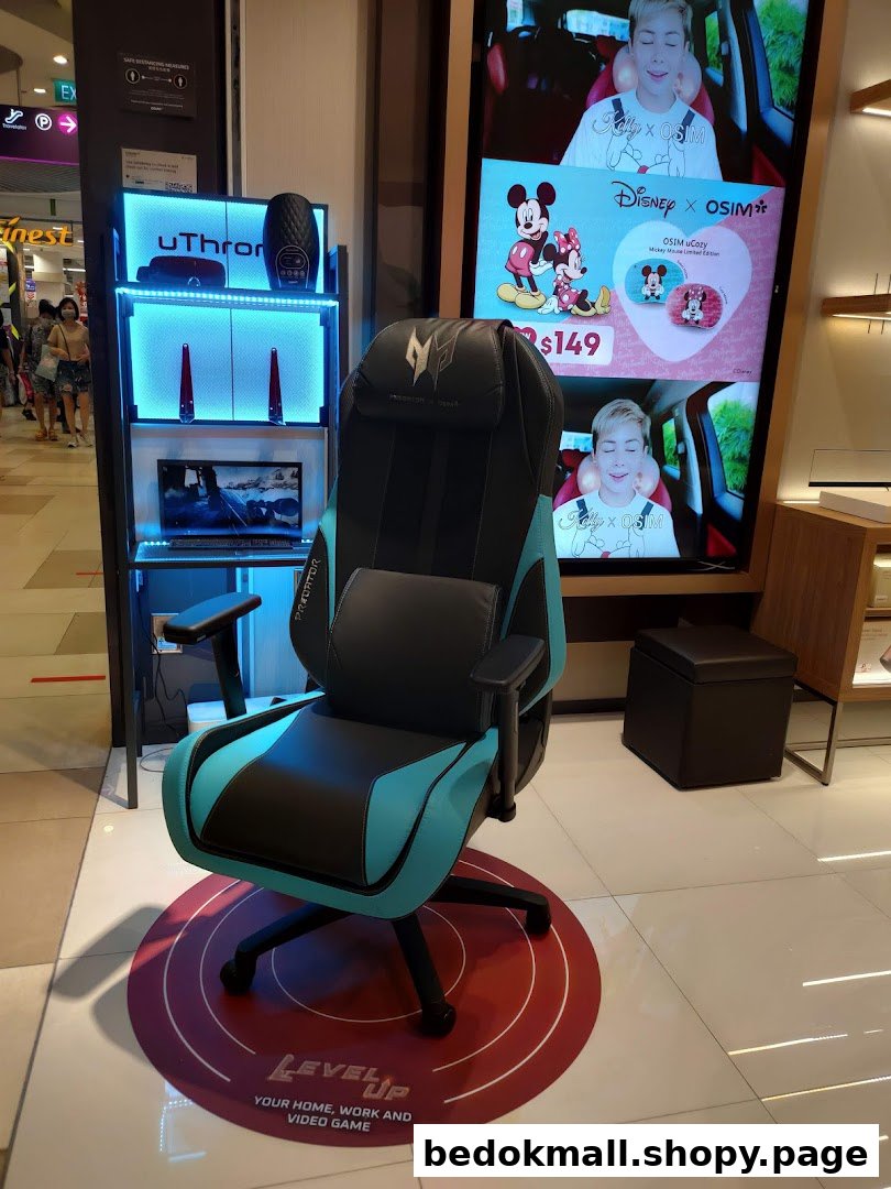 Interior shop display featuring a gaming chair, product shelf, and large digital screen.