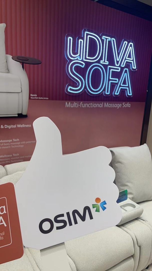 White massage sofa display with OSIM branding and a neon sign.