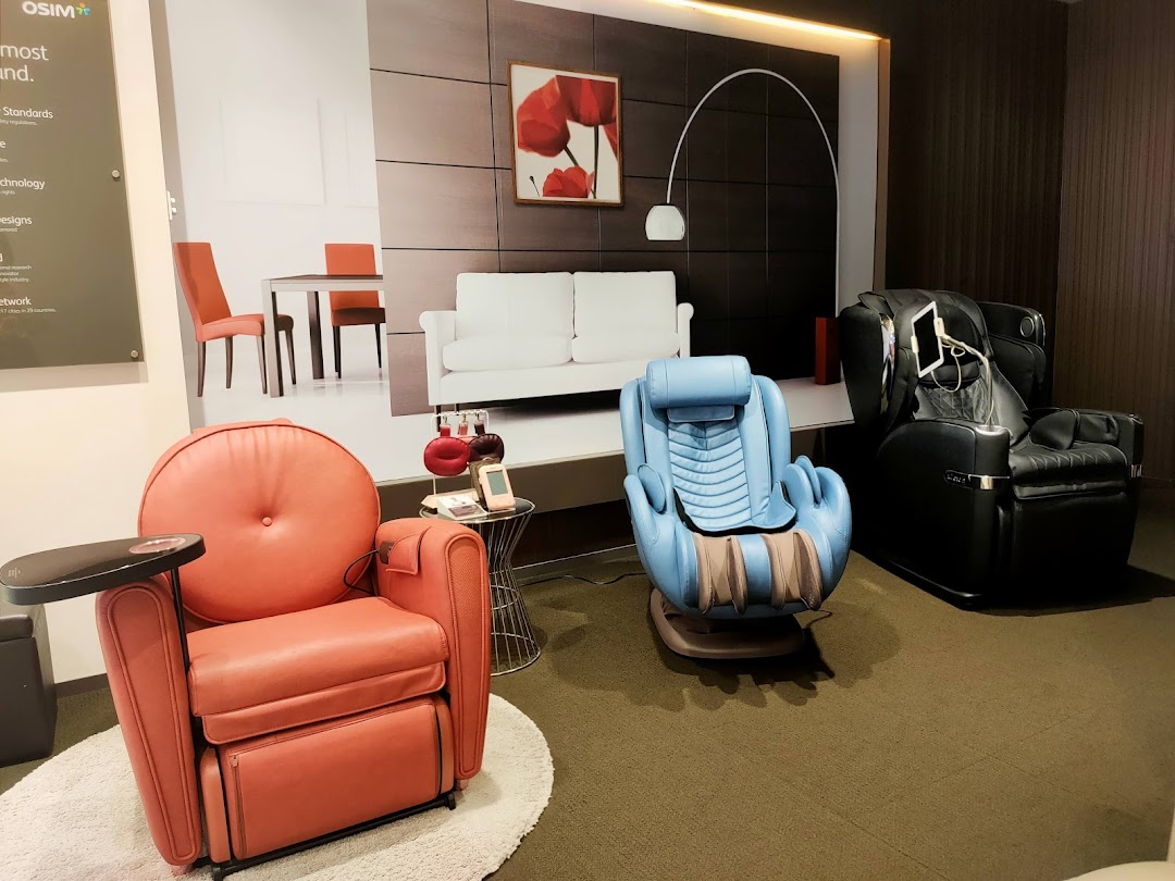 Three massage chairs displayed in a shop interior with a large wall graphic.