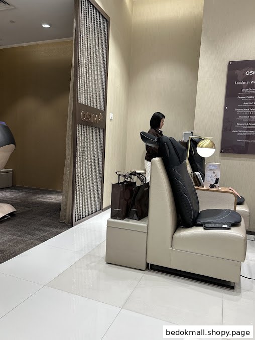 Interior view of an OSIM shop with a person and massage products.