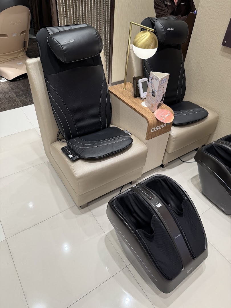Massage chairs and a foot massager displayed in a shop interior.