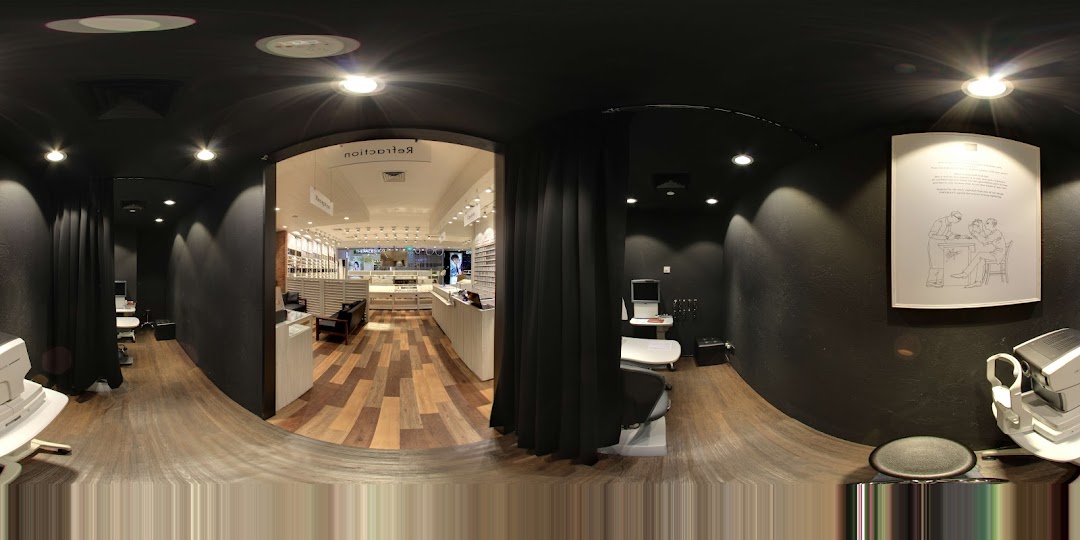Interior view of an optical shop with display cases and examination areas.