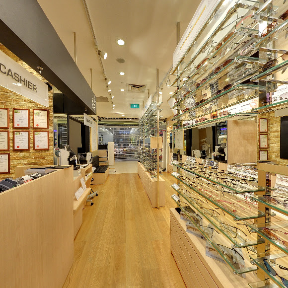 Interior view of an eyewear shop with displays of glasses and a cashier counter.