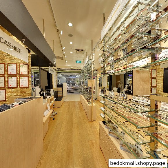 Interior view of an eyewear shop with displays of glasses and a cashier counter.