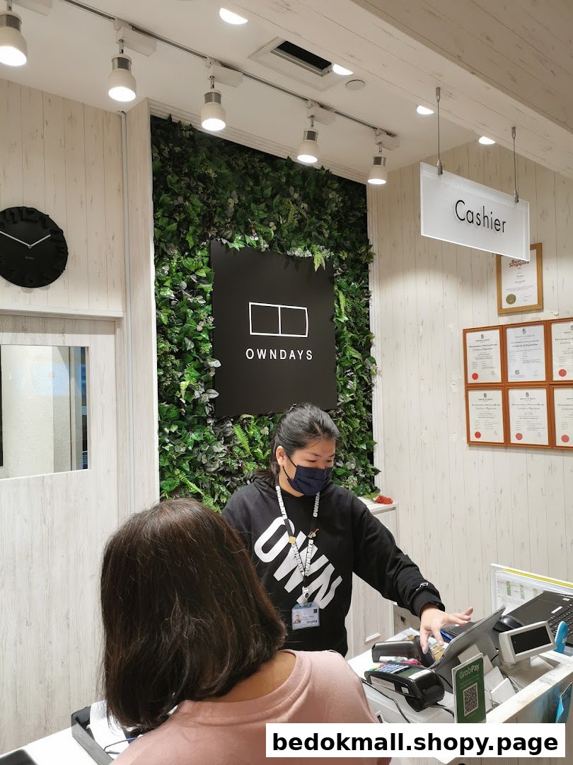 A staff member assists a customer at the cashier counter inside the shop.