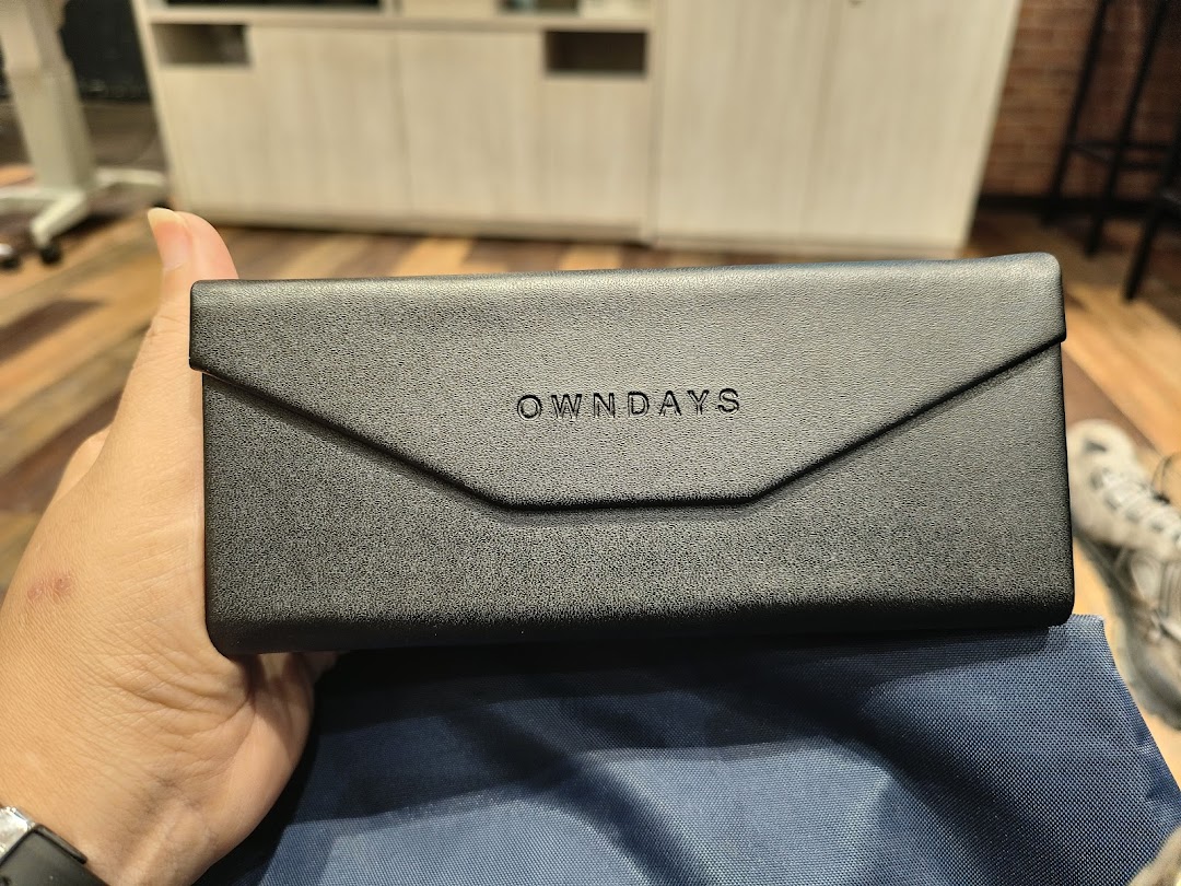 A person holds a black OWNDAYS eyeglasses case with the logo visible.