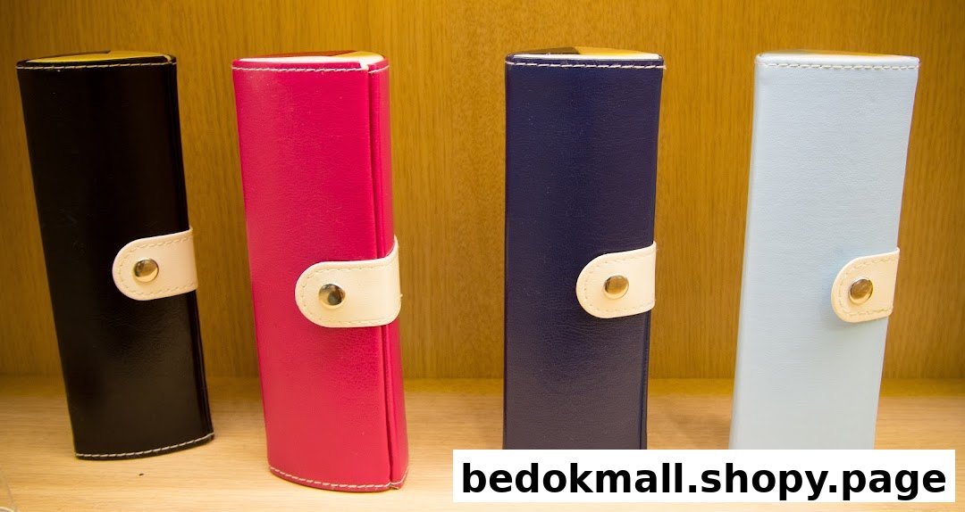 Four colorful cases, likely for glasses, displayed on a wooden shelf.