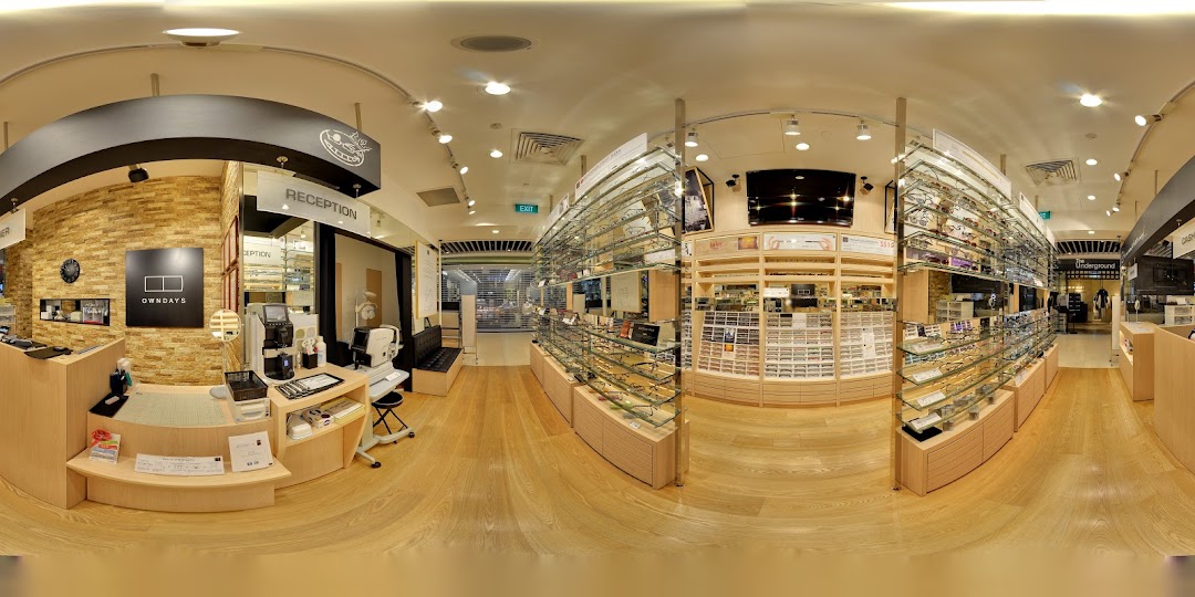 Interior view of an optical shop with eyeglasses displays and reception area.