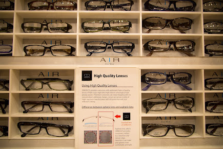 Eyeglasses displayed on shelves with a sign explaining high quality lenses.