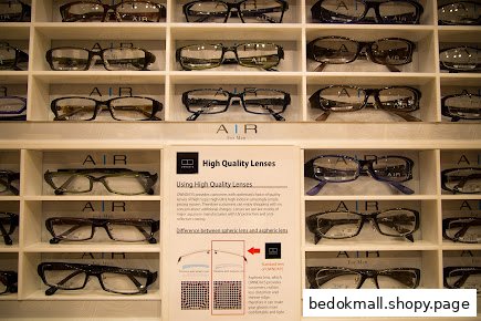 Eyeglasses displayed on shelves with a sign explaining high quality lenses.