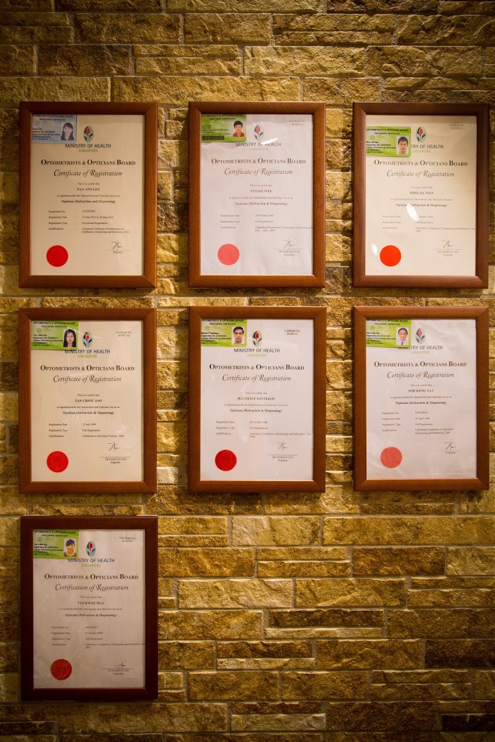 Framed professional certificates displayed on a textured wall inside the shop.