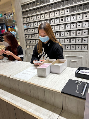 Two staff members behind a counter in a retail shop interior.