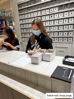 Two staff members behind a counter in a retail shop interior.