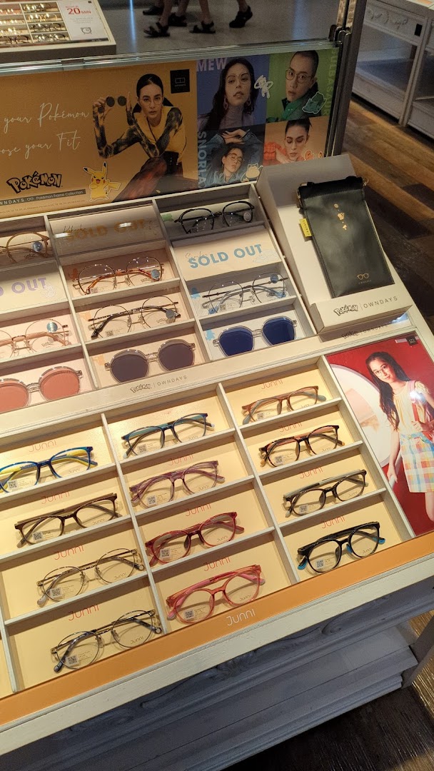 Display of various eyeglasses and promotional posters inside a shop.