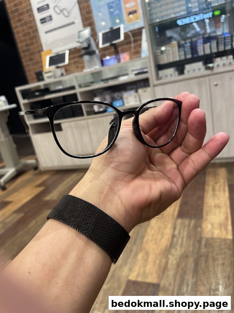 A hand holds eyeglasses inside an optical shop.