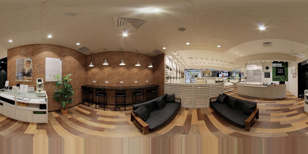 Panoramic view of a modern eyeglasses shop interior with displays, reception, and seating.