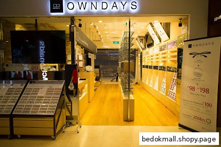 Entrance of an OWNDAYS eyewear shop with displays and a promotional banner.