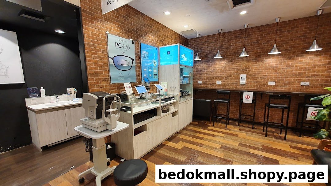 Interior of an optical shop with an eye exam machine, counter, and seating area.