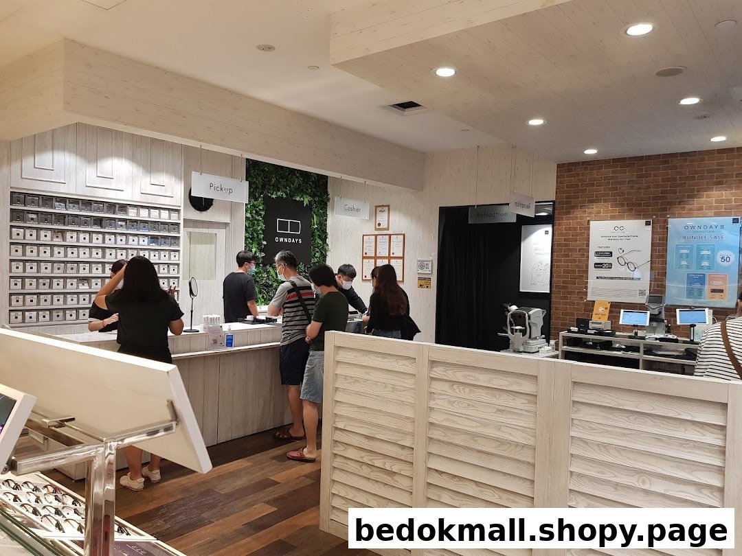Interior view of an eyewear shop with customers at a service counter.