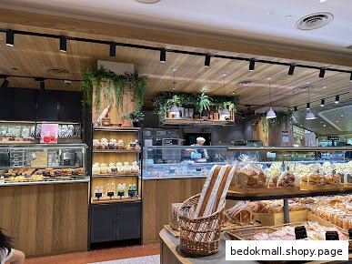Interior view of a bakery with display cases of bread and pastries.