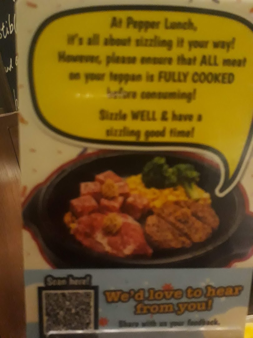 A sign with cooking instructions, food image, and a QR code for feedback.