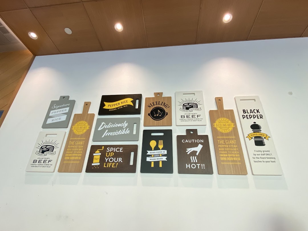 Decorative wall signs with food names and branding messages inside a shop.
