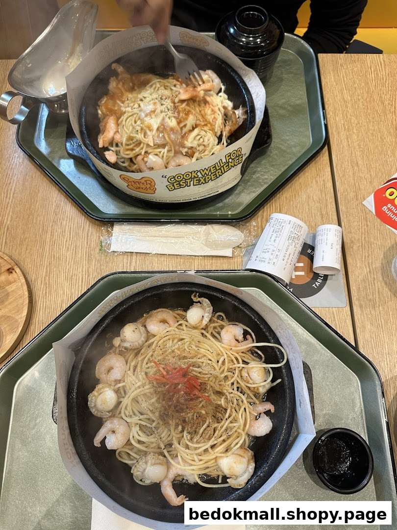 Two hot plates of steaming spaghetti and seafood served at a restaurant.