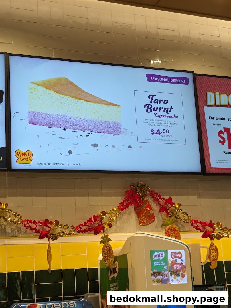 Digital menu board displaying cheesecake and price above a decorated counter.