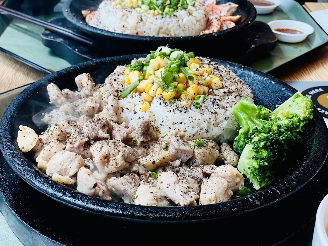 Hot plate with meat, rice, corn, and broccoli steaming.