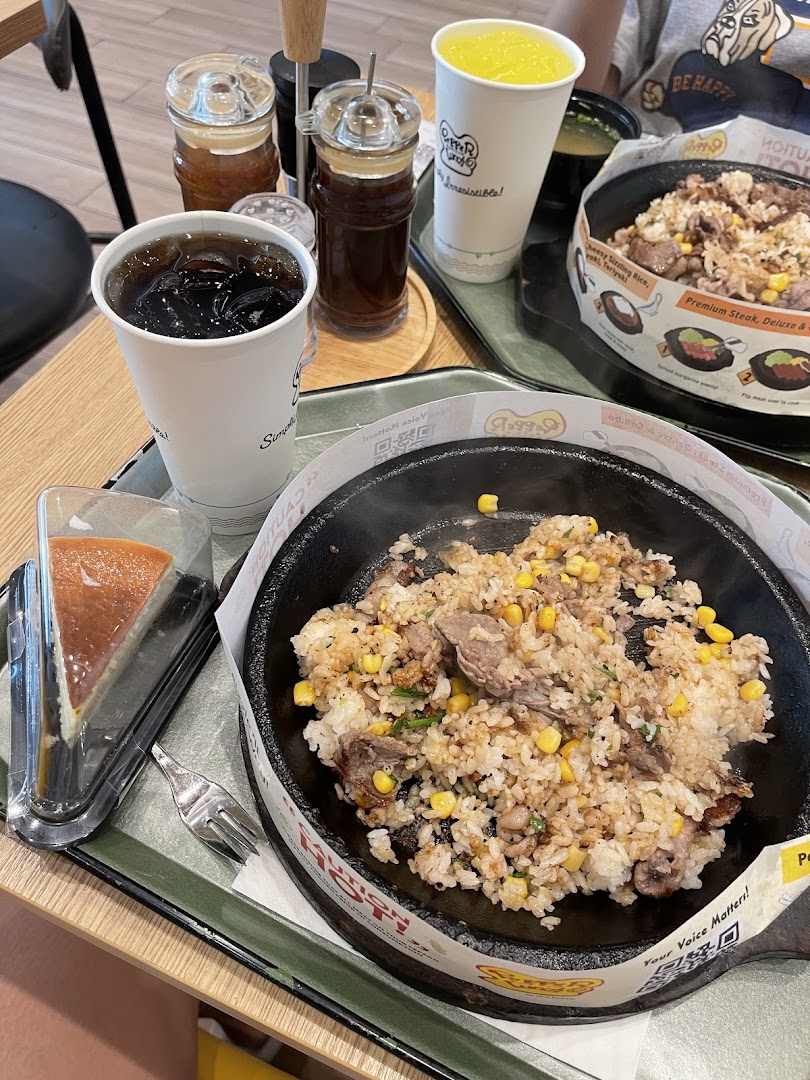 Sizzling rice, drinks, and cheesecake on a table in a restaurant setting.