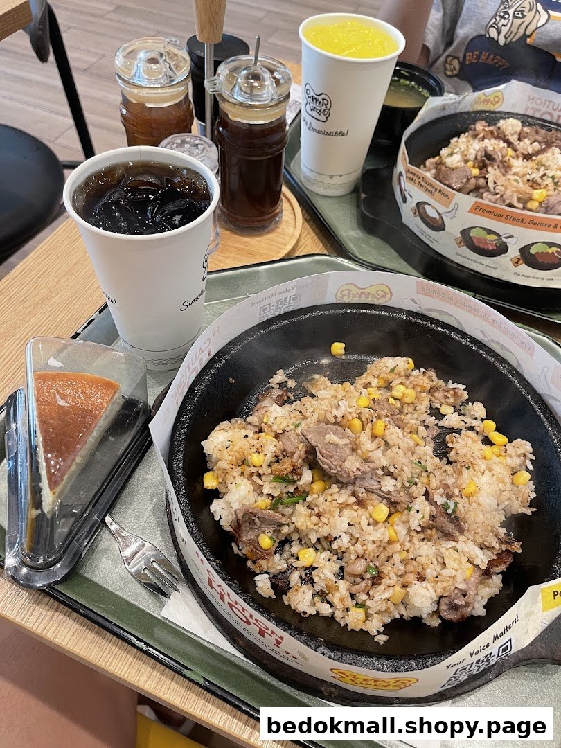 Sizzling rice, drinks, and cheesecake on a table in a restaurant setting.