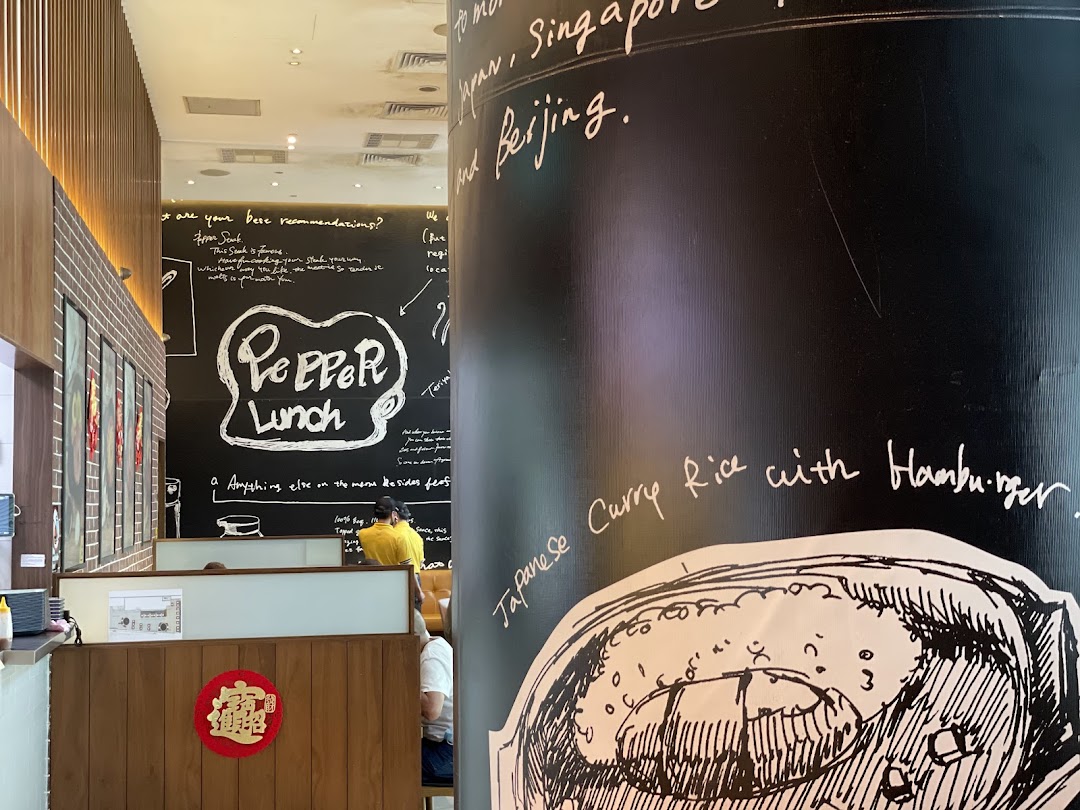 Interior view of Pepper Lunch restaurant with decorated walls and dining area.