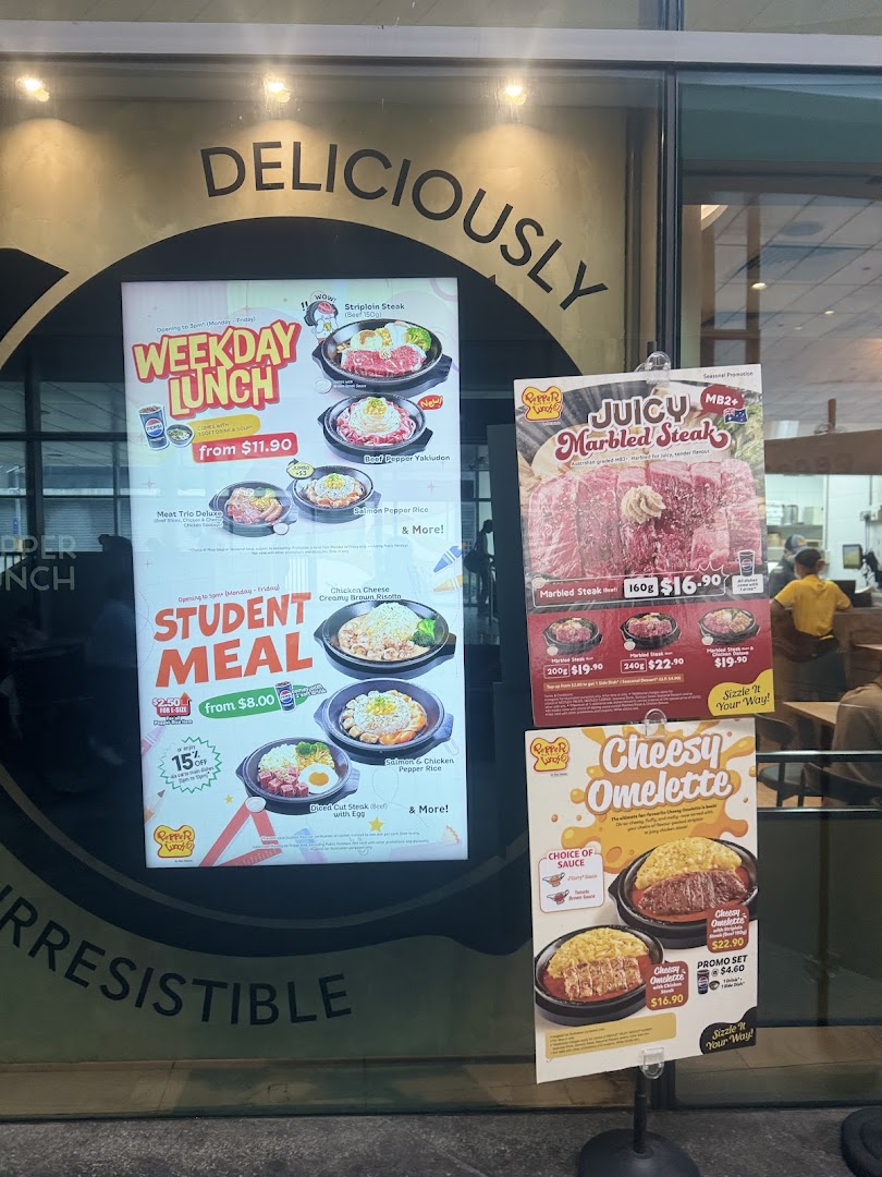 Various food menus and promotional offers displayed on a shop window.