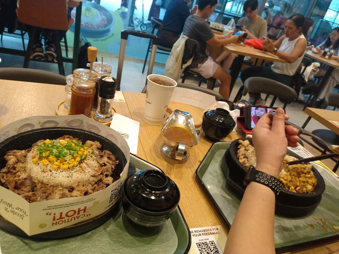 Diners eating hot plate meals at a restaurant table.