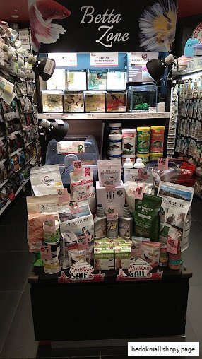 Interior view of a pet shop with a Betta fish display and various pet products.