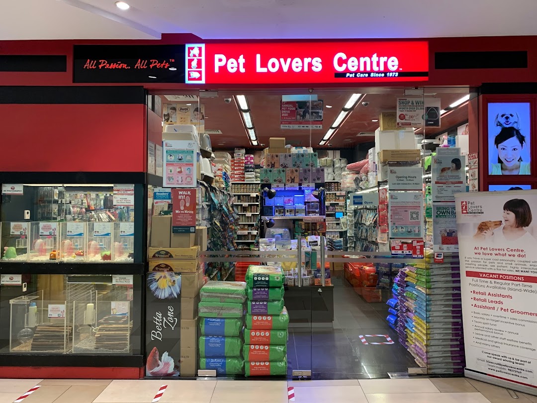 Front view of a pet store with red signage and glass entrance.