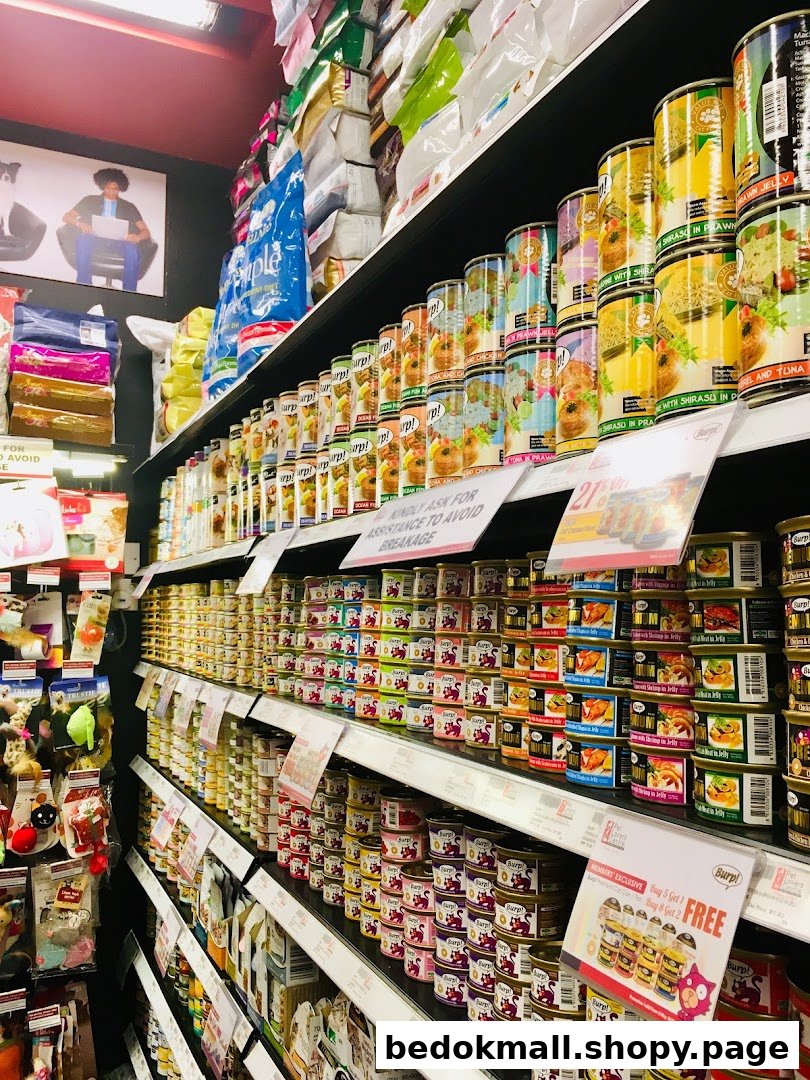 Shelves stocked with various pet food cans, bags, and pet toys inside a store.