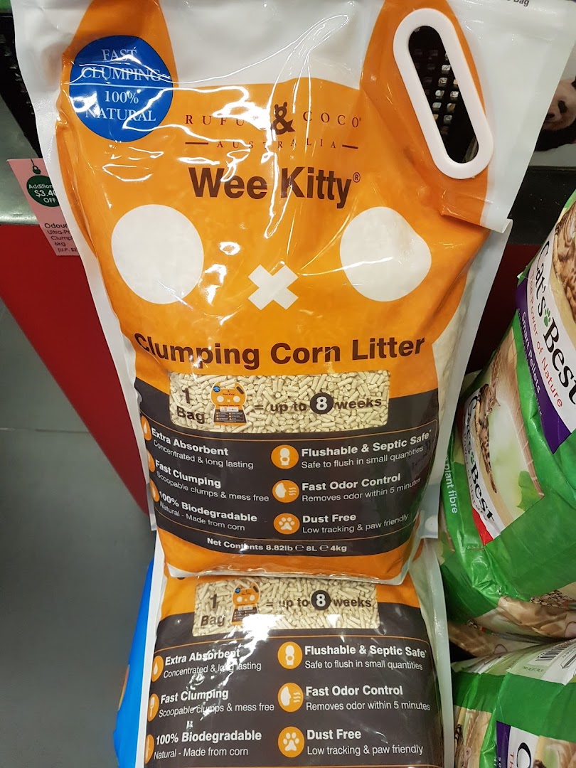 Bags of Wee Kitty clumping corn litter displayed on a retail shelf.