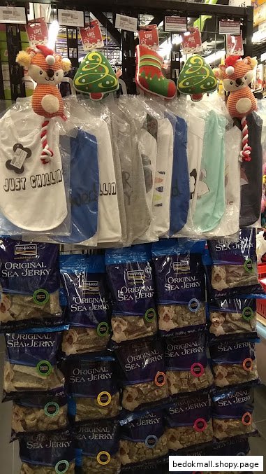 Display of pet clothes, sea jerky treats, and festive decorations inside a shop.