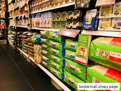 Shelves stocked with pet food and cat litter inside a retail store.