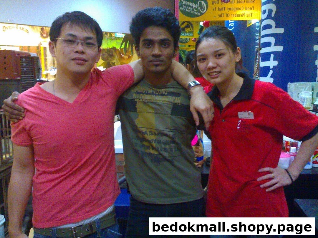 Three people posing inside a retail shop, likely staff members.