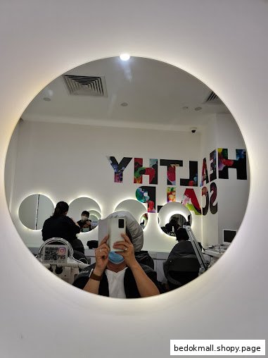 Interior view of a hair treatment shop reflected in a circular mirror.