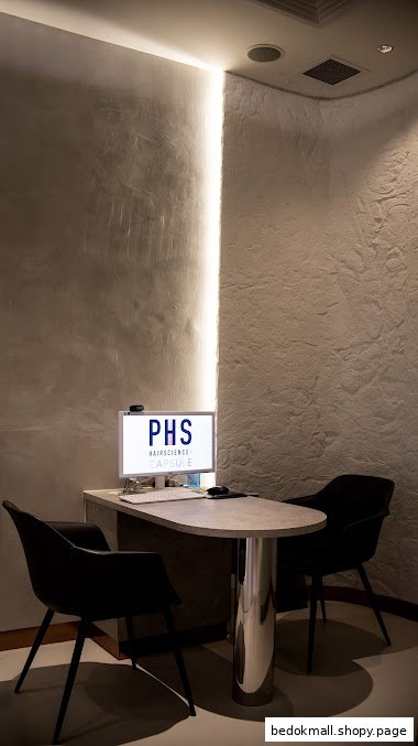 Interior shot of a modern reception desk with computer and two chairs.