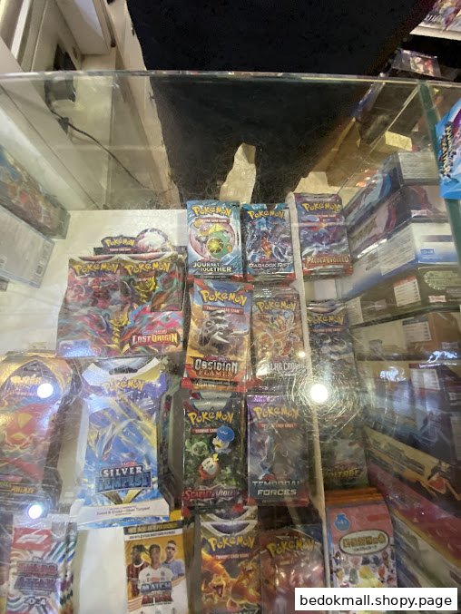 Close-up of various Pokémon trading card packs displayed in a glass case.