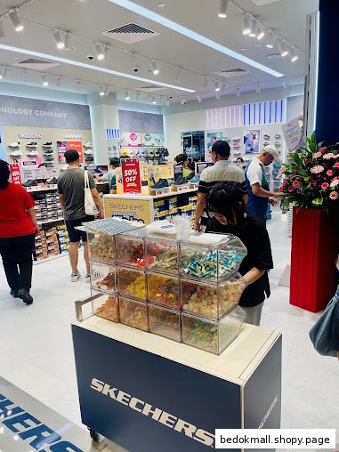 Interior of a Skechers shoe store with customers and a candy display.