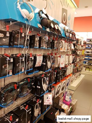 Shop interior with shelves displaying headphones and various electronic accessories.